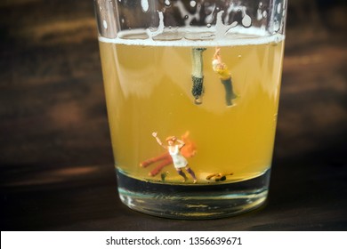 Anonymous, Unrecognizable Miniature People In A Glass Of Beer. Binge Drinking Concept. Tiny People With A Drinking Problem At A Crazy Party. Last Call, Or Time To Seek Help With A Drinking Problem.