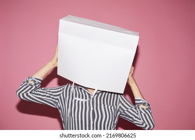 Anonymous woman in black and white shirt standing against pink wall and holding white paper bag over her head, shopping concept - Shutterstock ID 2169806625