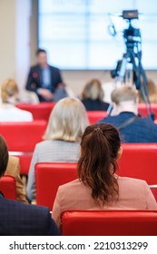 Anonymous Woman With Dark Hair Watching Presentation And Listening To Speaker During Business Conference