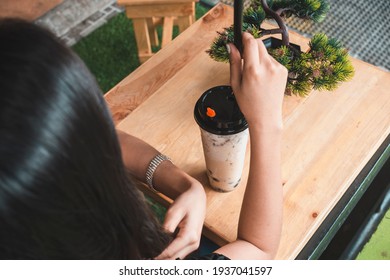 An Anonymous Woman With Her Order Of A Large Bubble Tea In A Simple Plastic Takeaway Cup. At A Milk Or Boba Tea Cafe Store.