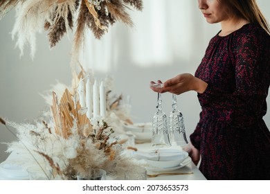 An Anonymous Woman Setting Up Christmas Dinner Table At Home