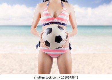 Anonymous Woman Wearing Bikini Holding A Soccer Ball At Beach