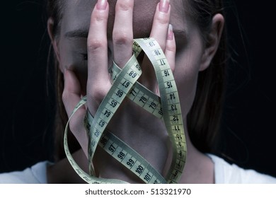 Anorexic Girl Covering Her Face With A Centimeter
