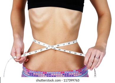 Anorexic and weight obsessed young woman, measuring her very thin and slim waist, torso with ribs and hip bones clearly showing, perfect for mental health and body dismorphia issues.