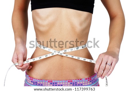 Anorexic and weight obsessed young woman, measuring her very thin and slim waist, torso with ribs and hip bones clearly showing, perfect for mental health and body dismorphia issues. Imagine de stoc © 