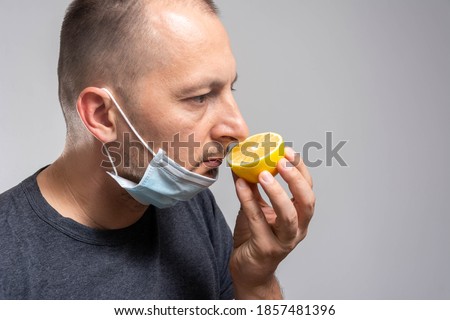 Anosmia or smell blindness, loss of the ability to smell, one of the possible symptoms of covid-19, infectious disease caused by corona virus. Man Trying to Sense Smell of a Lemon