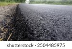 Another close-up of the newly paved road, this time focusing on the sand beside the road.