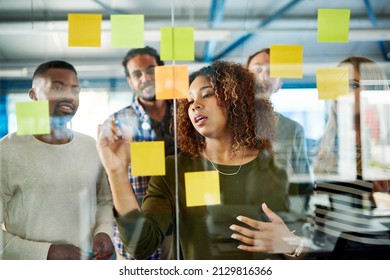Another idea Lets write it down. Shot of colleagues having a brainstorming session with sticky notes at work.