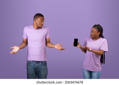 Another Life Online, Cheating Concept. Angry Black Woman Checking Her Boyfriend Mobile Phone, Showing Provocative Messages And Asking Man For Explanation, Guy Spreading Hands, Violet Studio Background