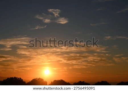 Another sun is setting, among the clouds.