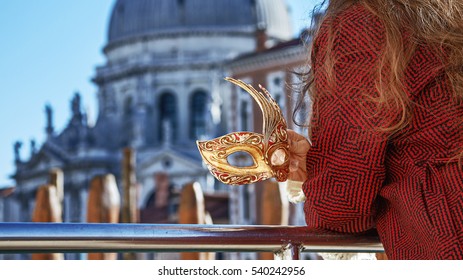 Another world vacation. Closeup on elegant Venetian mask in hand of woman in fur hat on embankment in Venice, Italy - Powered by Shutterstock