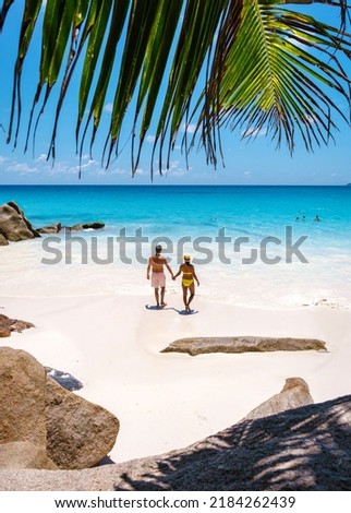 Anse Georgette Praslin Seychelles, a young couple of men and women on a tropical beach during a luxury vacation in Seychelles. Tropical beach Anse Georgette Praslin Seychelles.