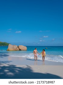 Anse Lazio Praslin Seychelles, a young couple of men and women on a tropical beach during a luxury vacation in Seychelles. Tropical beach Anse Lazio Praslin Seychelles