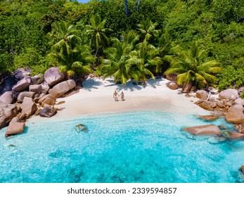 Anse Lazio Praslin Seychelles a young couple of men and women on a tropical beach during a luxury vacation there. Tropical beach Anse Lazio Praslin Seychelles Islands on a sunny day with a blue sky - Powered by Shutterstock