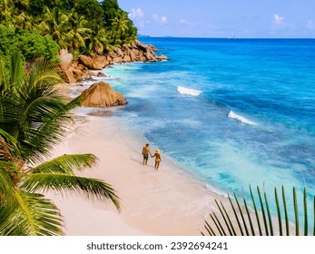 Anse Patates Beach La Digue Island Seychelles, Drone aerial view of La Digue Seychelles bird eye view of a tropical Island, couple men and woman walking at the beach during sunset at a luxury vacation