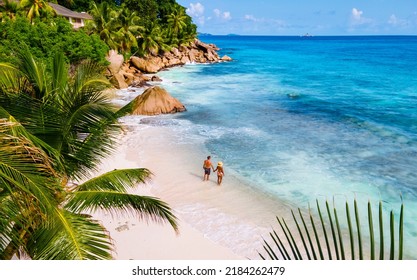 Anse Patates, La Digue Seychelles, a young couple of men and women on a tropical beach during a luxury vacation in Seychelles. Tropical beach Anse Patates, La Digue Seychelles - Powered by Shutterstock