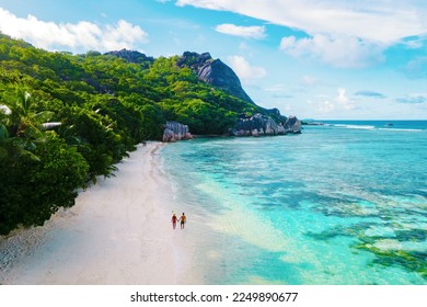 Anse Source d'Argent beach, La Digue Island, Seychelles, Drone aerial view of La Digue Seychelles bird eye view. of tropical Island, couple men, and woman walking at the beach during sunset
