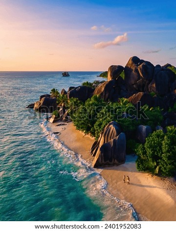 Anse Source d'Argent beach La Digue Island Seychelles, Drone aerial view of La Digue Seychelles bird eye view of tropical Island, couple men and woman walking at the beach during sunset