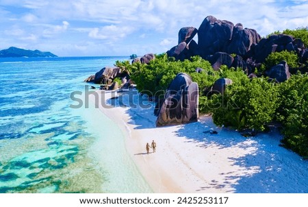 Anse Source d'Argent beach, La Digue Island, Seychelles, Drone aerial view of La Digue Seychelles bird eye view.of tropical Island, couple men and woman walking at the beach during sunset