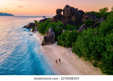 Anse Source d'Argent, La Digue Seychelles, a young couple of Caucasian men and Asian women on a tropical beach during a luxury vacation in Anse Source d'Argent, La Digue Seychelles