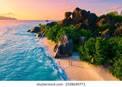 Anse Source d'Argent, La Digue Seychelles, a young couple of men and women on a tropical beach during a luxury vacation in Seychelles. Tropical beach Anse Source d'Argent, La Digue Seychelles
