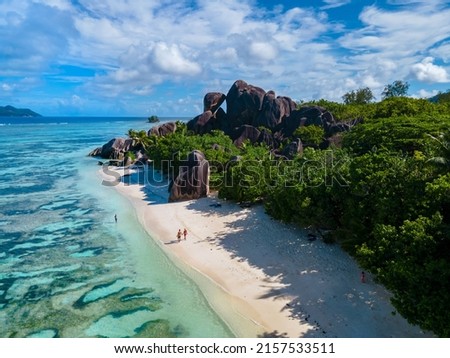 Anse Source d'Argent, La Digue Seychelles, a young couple of men and women on a tropical beach during a luxury vacation in Seychelles. Tropical beach Anse Source d'Argent, La Digue Seychelles