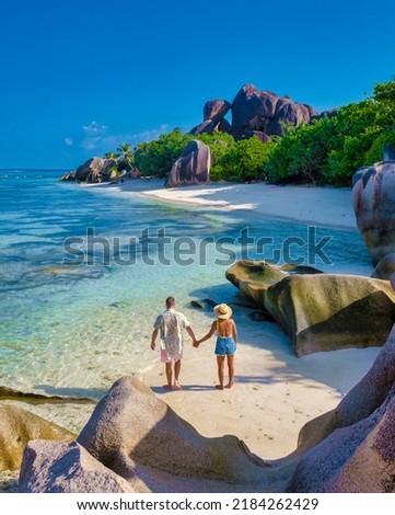 Anse Source d'Argent, La Digue Seychelles, a young couple of Caucasian men and Asian women on a tropical beach during a luxury vacation in Anse Source d'Argent, La Digue Seychelles