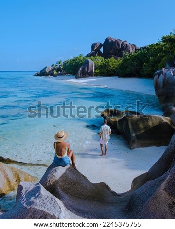 Anse Source d'Argent La Digue Island, Seyshelles, couple walking at the beach luxury vacation, turqouse colored ocean and tropical beach