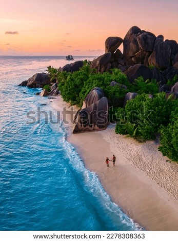 Anse Source d'Argent, La Digue Seychelles, a young couple of Caucasian men and Asian women on a tropical beach during a luxury vacation in Anse Source d'Argent, La Digue Seychelles