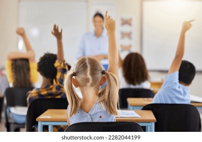 Answering, back and children raising hand in class for a question, answer or vote at school. Teaching, academic and a student asking a teacher questions while learning, volunteering or voting - Shutterstock ID 2282044199