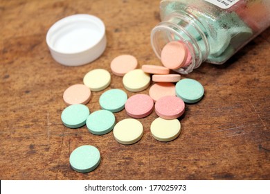 Antacid Bottle Spilled Out Over Wood Background