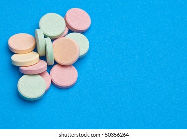 Antacid Pills On A Bright Blue Background Create A Border With Copy Space.