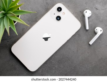 Antalya, Turkey - August 19, 2021: Back view of new iPhone 12s or iPhone 13 and Apple Airpods 2 headphones.