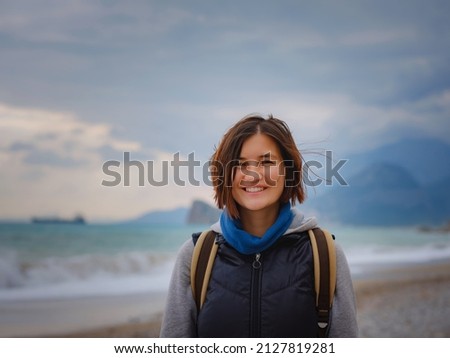 antalya, turkey, winter walk by the mediterranean sea. Attractive young woman standing on a windy cold beach.