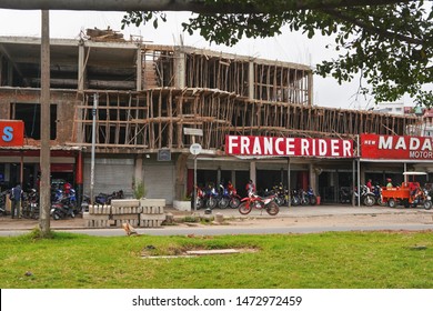 Antananarivo, Madagascar - April 24, 2019: Wooden Scaffolding On Building Where Another Floor Is Being Built Above Bike Shop. Madagascar Is Poor, People Can't Afford To Use Expensive Steel Tubes.