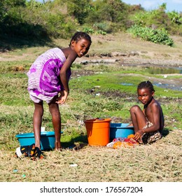 ANTANANARIVO, MADAGASCAR - JULY 3, 2011: Unidentified Madagascar girl clean their clothes in the water. People in Madagascar suffer of poverty due to slow development of the country