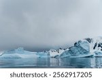 An Antarctic landscape shot near Cuverville island, highlighting mountains and icebergs.