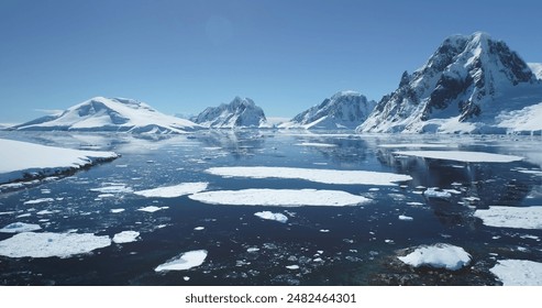 Antarctica ocean bay aerial landscape in sunny day. Melting ice floe on water surface, blue sky, snow covered mountains in background. Antarctic travel exploration. Discover beauty of South Pole - Powered by Shutterstock