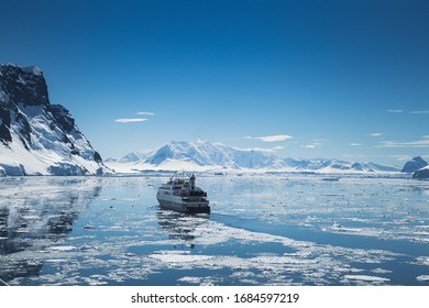 Antarctica Peninsula Landscape With People, Ships, Tender Boats, Penguins, Icebergs And Mountains