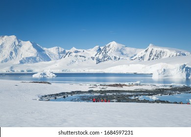 Antarctica Peninsula Landscape With People, Ships, Tender Boats, Penguins, Icebergs And Mountains