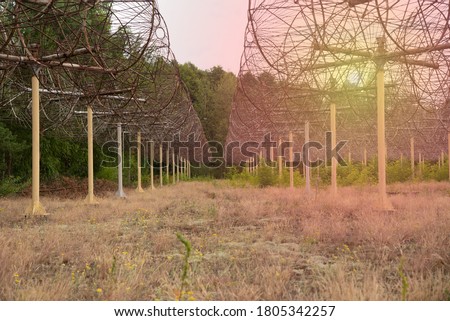 Antenna Array. A long row of radio telescopic antennas against a background of blue sky and green grass. Array of radio-telescopes