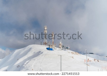Antennas of communication equipment on top of a snowy mountain. Telecommunications tower high in the mountains. Rosa Khutor.