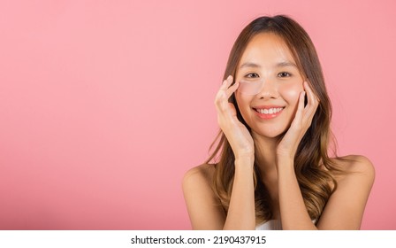 Anti Aging. Asian Beautiful Young Woman Smiling Mask Cosmetic Patches Gel Under The Eyes, Portrait Female Applying Medical Hydrogel Eye Patch On Face, Studio Shot Isolated On Pink Background, Skincare