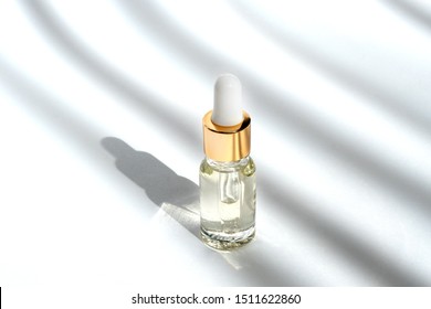 Anti aging serum with collagen and peptides in glass bottle with dropper on white background with shadows. Anti-age product, luxury body care and organic science concept. 