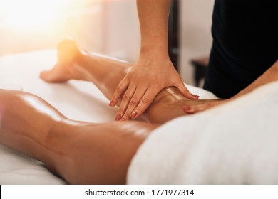 Anti Cellulite Massage. Masseuse Massaging A Calf Area Of A Female Leg To Reduce Cellulite 