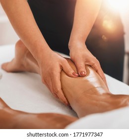 Anti Cellulite Massage. Masseuse Massaging A Calf Area Of A Female Leg To Reduce Cellulite 