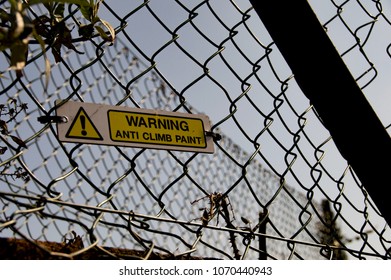 Anti Climb Paint Sign Attached To Chain Link Fence On Building Site