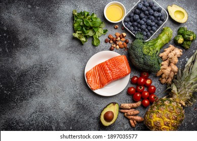 Anti inflammatory diet concept. Set of foods that help to reduce inflammation - plant based ingredients, fresh fruit, green vegetables. Healthy diet products, top view, stone background copy space