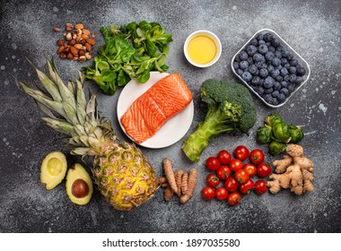 Anti inflammatory diet concept. Set of foods that help to reduce inflammation - plant based ingredients, fresh fruit, green vegetables. Healthy diet products, top view, stone background
