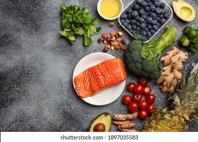 Anti inflammatory diet concept. Set of foods that help to reduce inflammation - plant based ingredients, fresh fruit, green vegetables. Healthy diet products, top view, stone background copy space